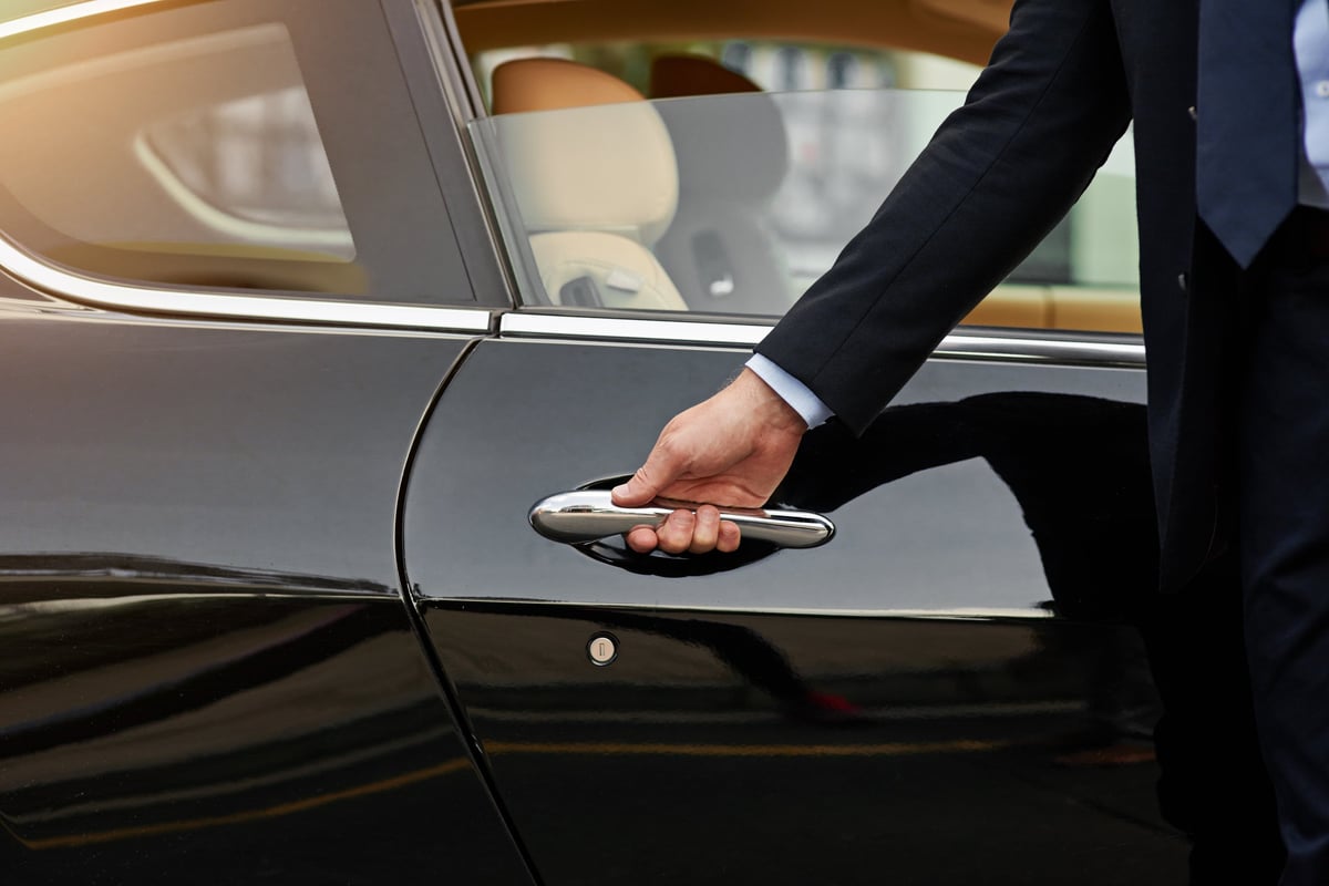 Professional chauffeur in white gloves opening Rolls-Royce door on Las Vegas Strip
