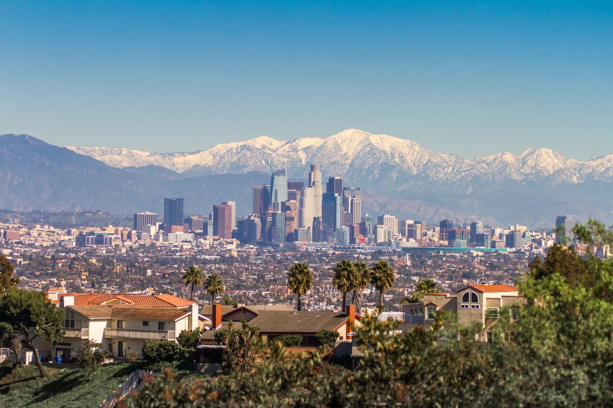 Snowed peaks mountains and downtown cityscape