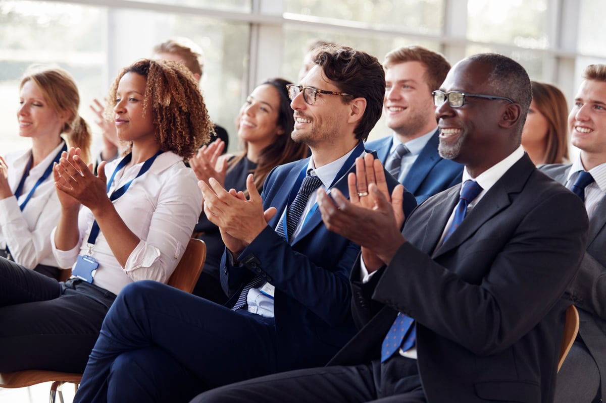 Smiling audience applauding at a business seminar