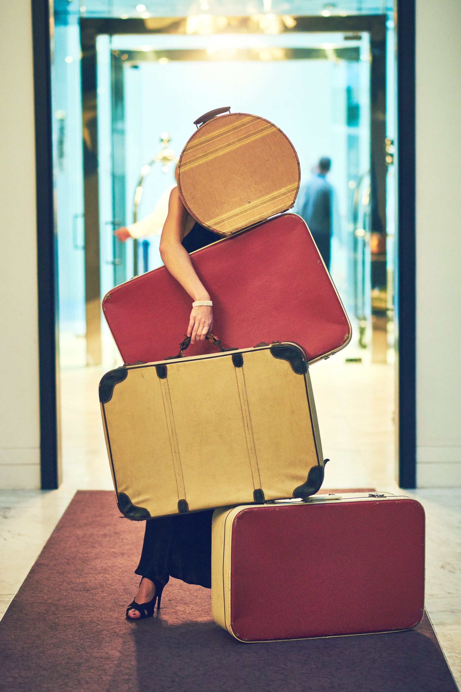 Woman carrying luxury luggage through hotel lobby