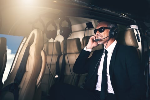 Businessman using headset while traveling in helicopter