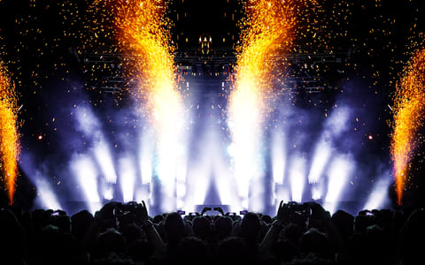 Concert stage with bright lights and fireworks