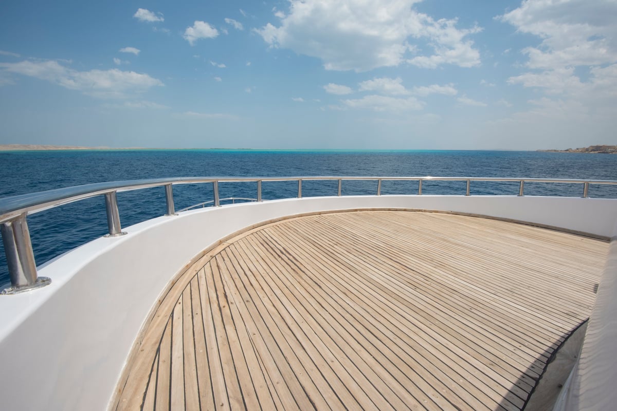 View over the bow of a large luxury motor yacht on tropical open ocean