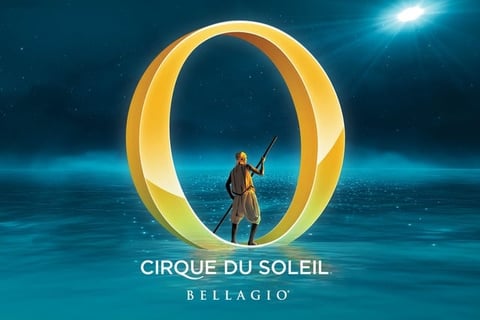 Cirque du Soleil performer standing in illuminated golden O ring against blue starry background at Bellagio