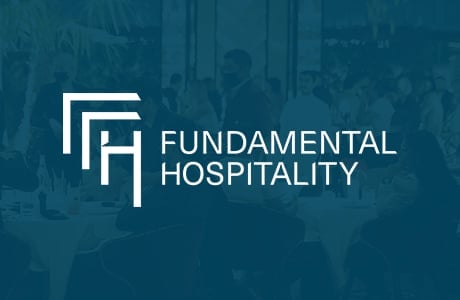 Fundamental Hospitality logo with white geometric symbol on teal background and blurred crowd