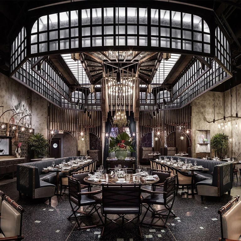 Upscale restaurant dining room with symmetrical layout, ornate ceiling with gridded skylight, elegant furnishings, and central chandelier