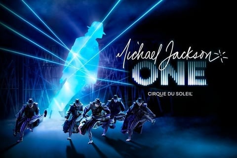 Michael Jackson ONE Cirque du Soleil promotional image showing performers in black outfits under blue glowing lights and holographic effects