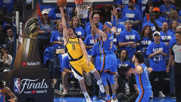 NBA Finals game with a player in yellow jersey attempting a layup against defenders in blue jerseys during a playoff match
