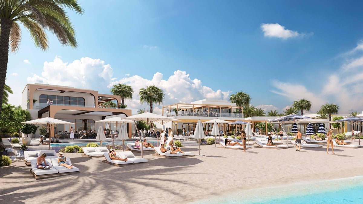 Luxury beach resort with white cabanas, lounge chairs, and pool area under clear blue sky with palm trees