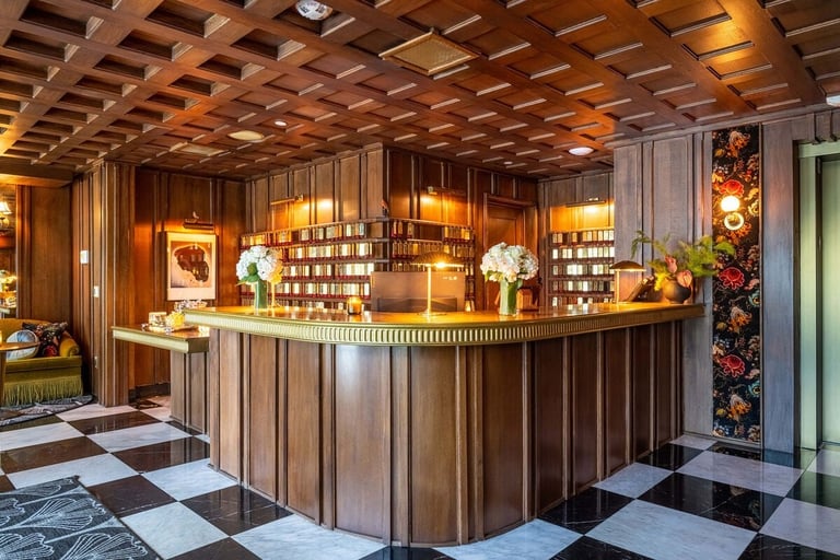 Elegant spa reception desk with warm wood paneling, checkered flooring, ambient lighting, and decorative flowers
