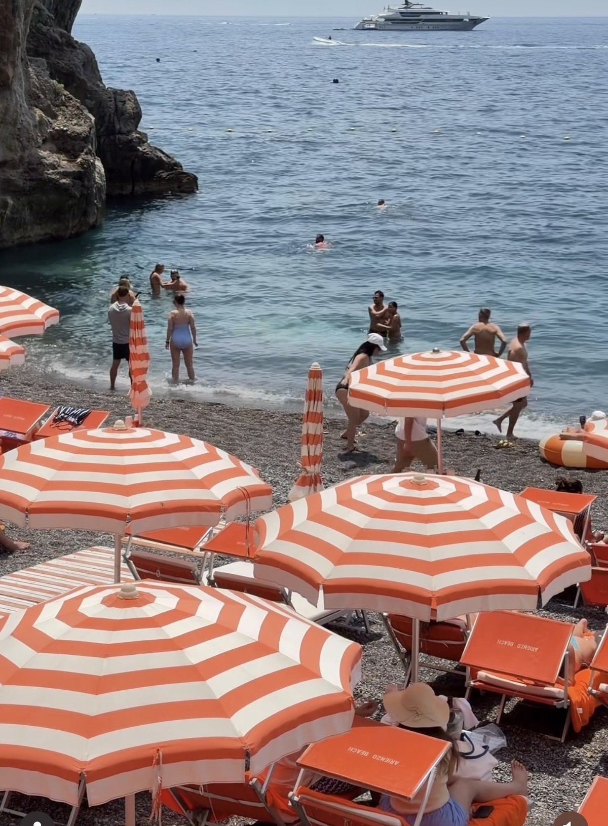 Arienzo Beach Club in Positano with iconic striped umbrellas and crystal waters