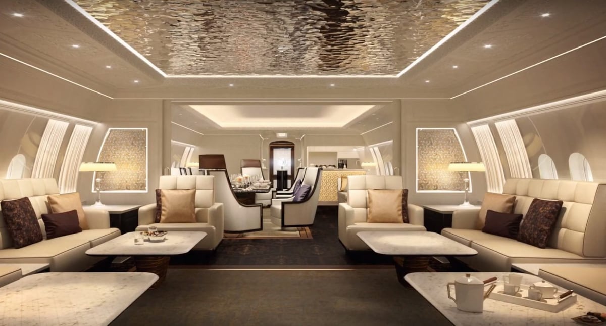 Luxurious aircraft cabin interior with cream leather seating, wooden ceiling, ambient lighting, and modern furnishings throughout the spacious cockpit area