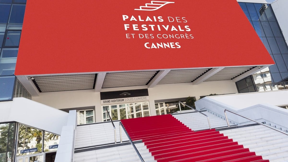 Palais des Festivals in Cannes with red carpet staircase and prominent red signage on the building facade