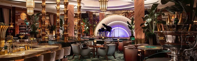 Luxurious hotel lobby with gold columns, elegant seating, ornate chandeliers, and a glowing purple-lit archway in the background
