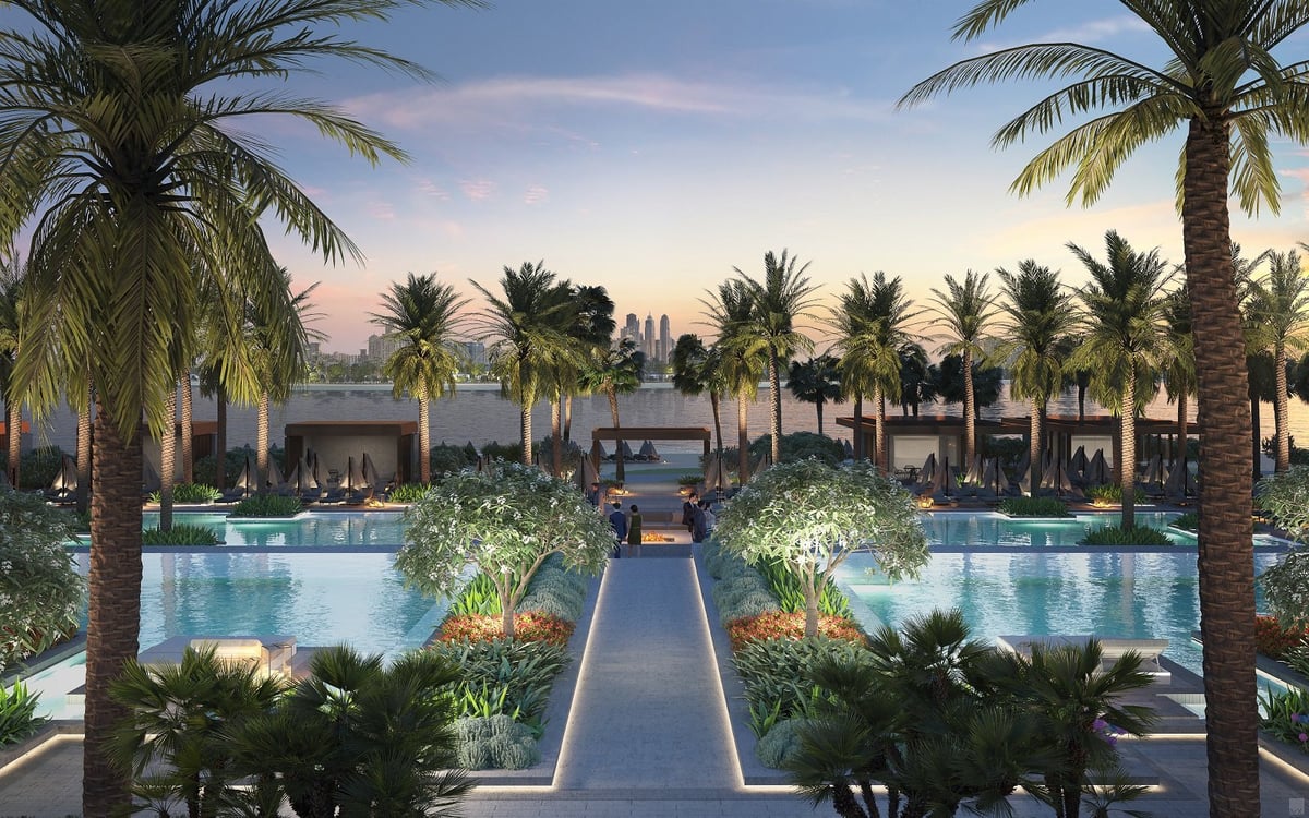 Luxury resort courtyard at sunset with palm trees, reflecting pools, manicured gardens, and central walkway.