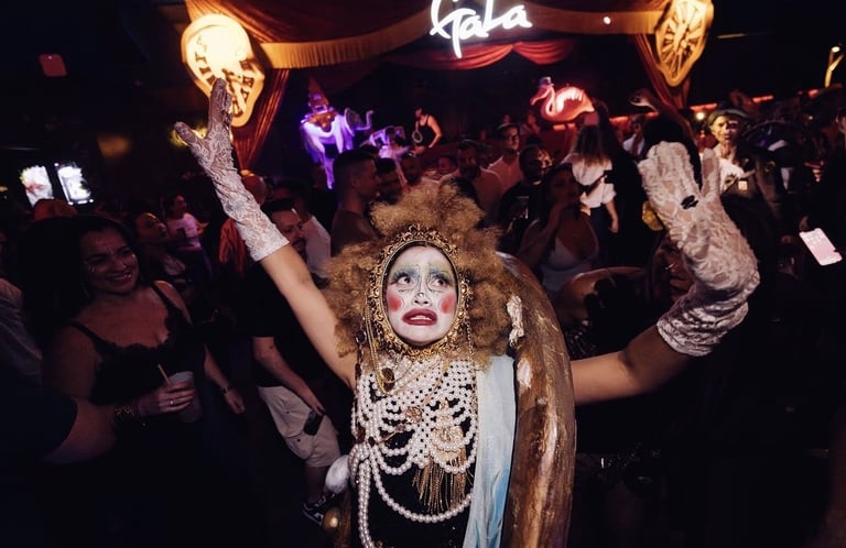 Glamorous performer in pearl necklaces and gold fabric dancing at crowded nightclub venue with neon signs